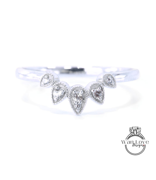 A silver ring with a unique design featuring a central diamond surrounded by smaller diamonds arranged in a fan-like pattern.