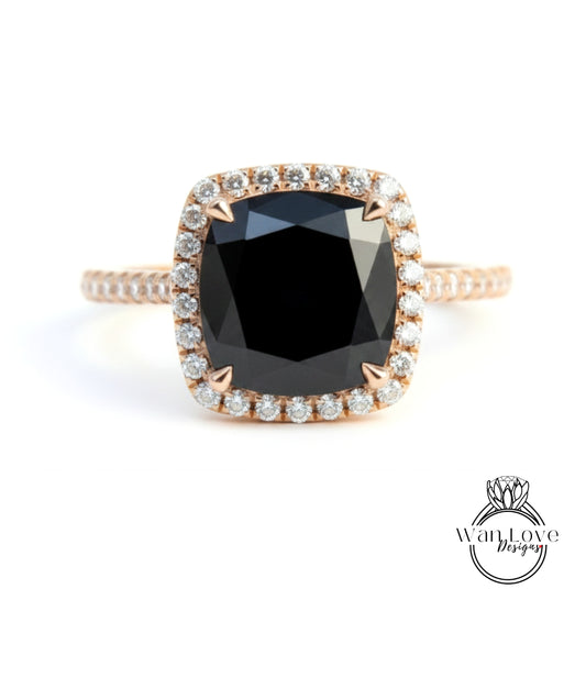 A gold ring with a large black diamond as the centerpiece, surrounded by smaller diamonds.