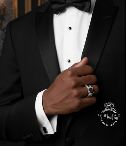 A close-up of a man's hand wearing a black tuxedo jacket and cufflinks, with a ring visible on his finger.