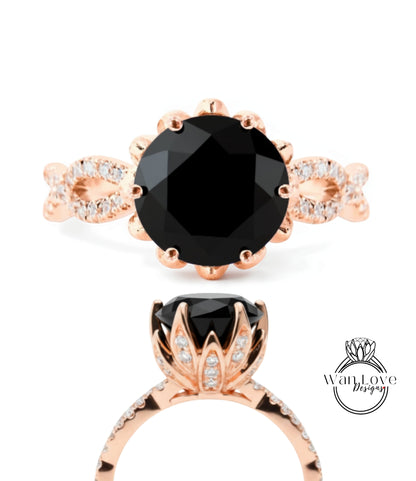a beautiful rose gold ring with a large black gemstone, likely a diamond, set in a delicate flower-like design.