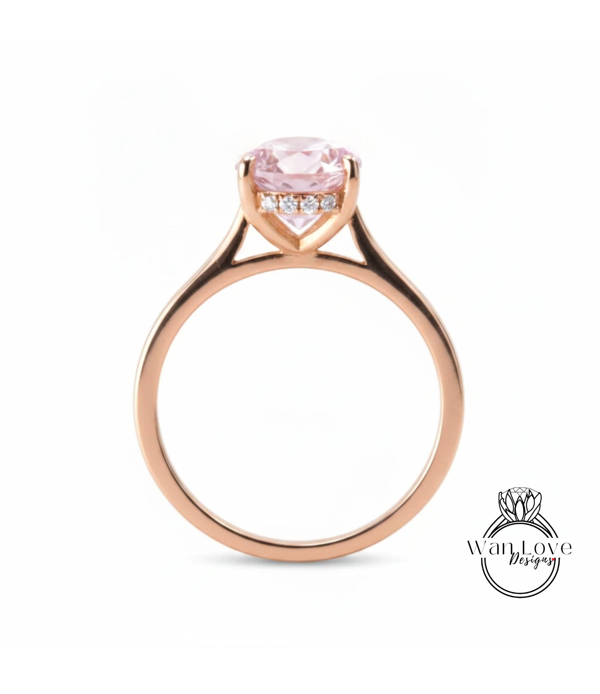 A gold ring with a pink gemstone, possibly a diamond, set in the center of the band.