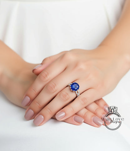 A close-up image of a person's hands wearing a ring with a large blue gemstone.