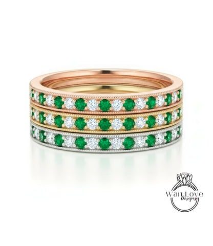 A stack of three rings, each with a band of green and white diamonds.