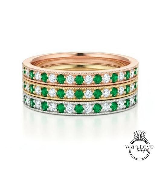 A stack of three rings, each with a band of green and white diamonds.