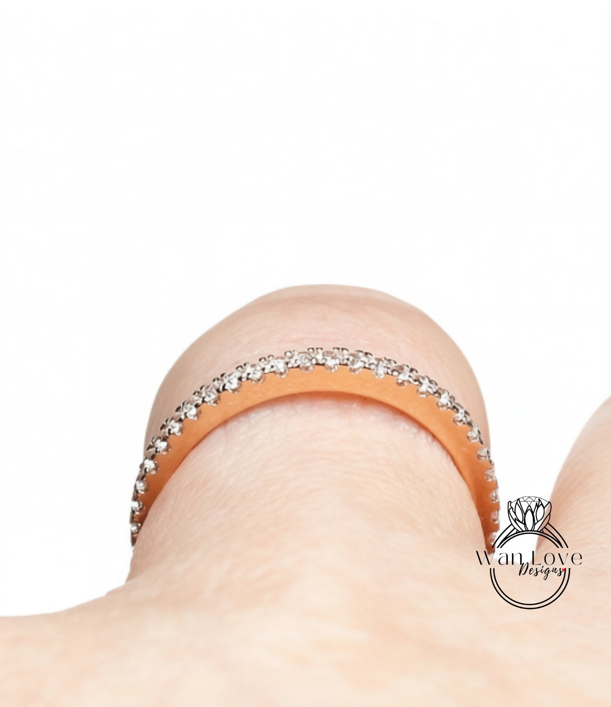A close-up view of a person's wrist wearing a gold-colored ring with a row of small diamonds along the band.