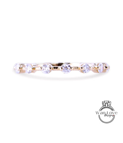 A gold ring with a row of clear diamonds set in it.