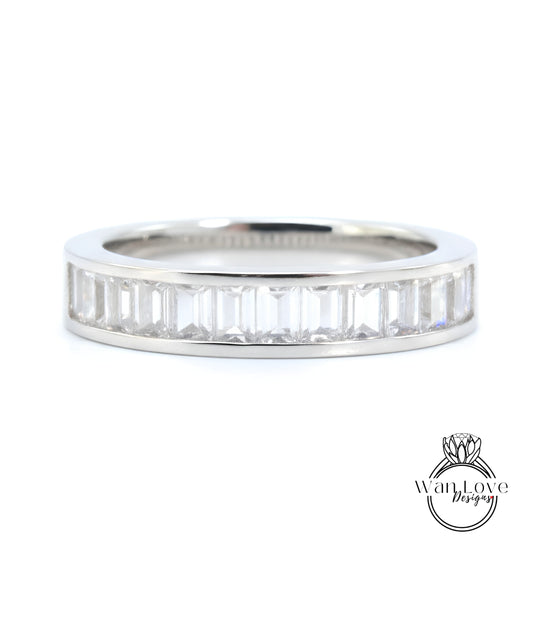 A silver band ring with a row of clear gemstones set in it.