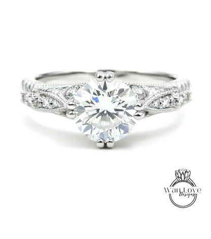 A close-up view of a diamond engagement ring with a large central diamond surrounded by smaller diamonds on either side.