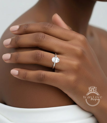 A close-up of a person's hand wearing a diamond engagement ring.
