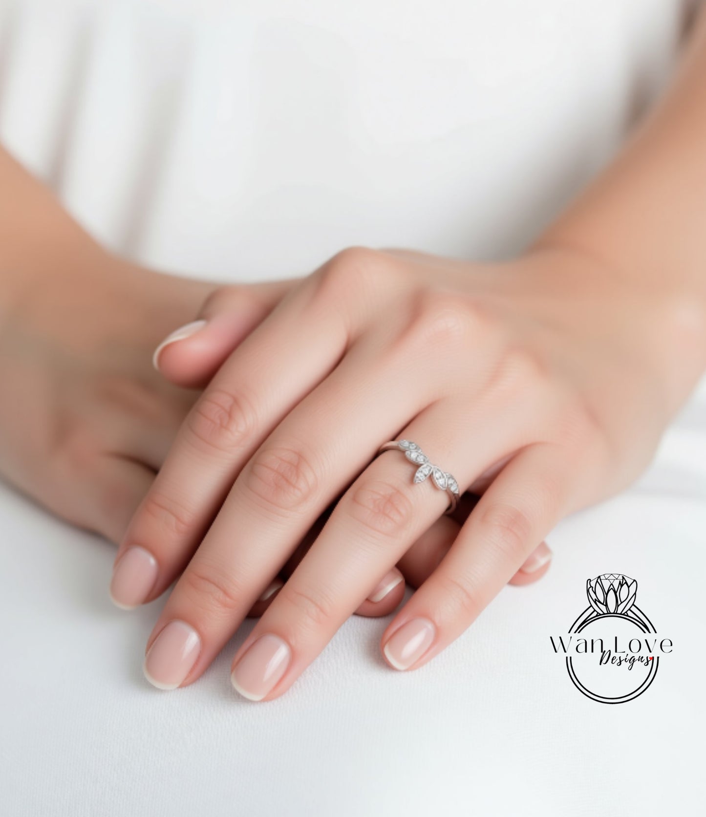 A close-up of a person's hand wearing a ring, with the ring's design visible.