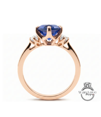 A gold ring with a large blue gemstone, possibly a sapphire, set in a three-pronged design.