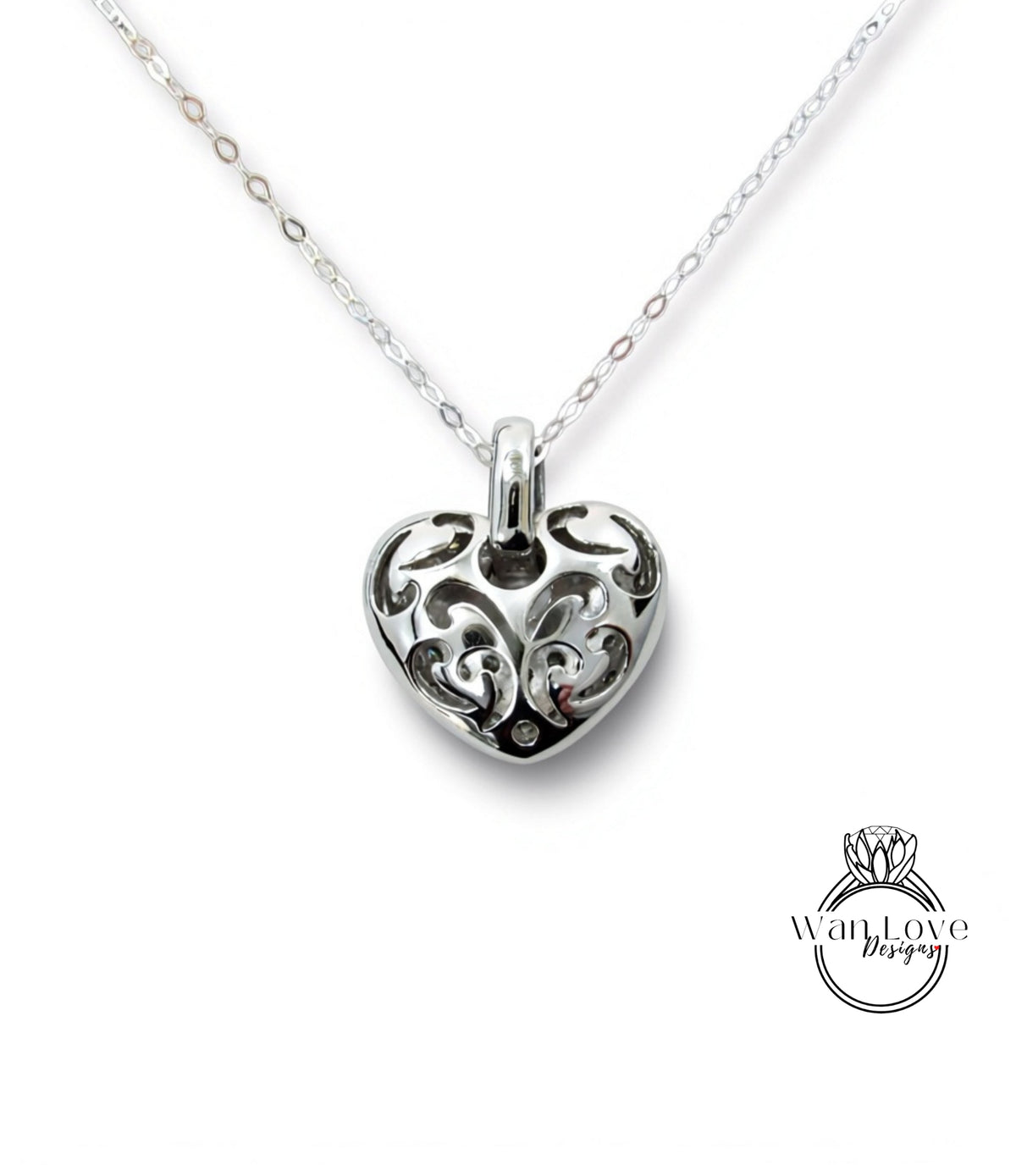 A silver heart-shaped pendant with an intricate floral design on a chain.