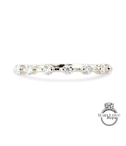 A silver ring with a row of clear diamonds set in it.