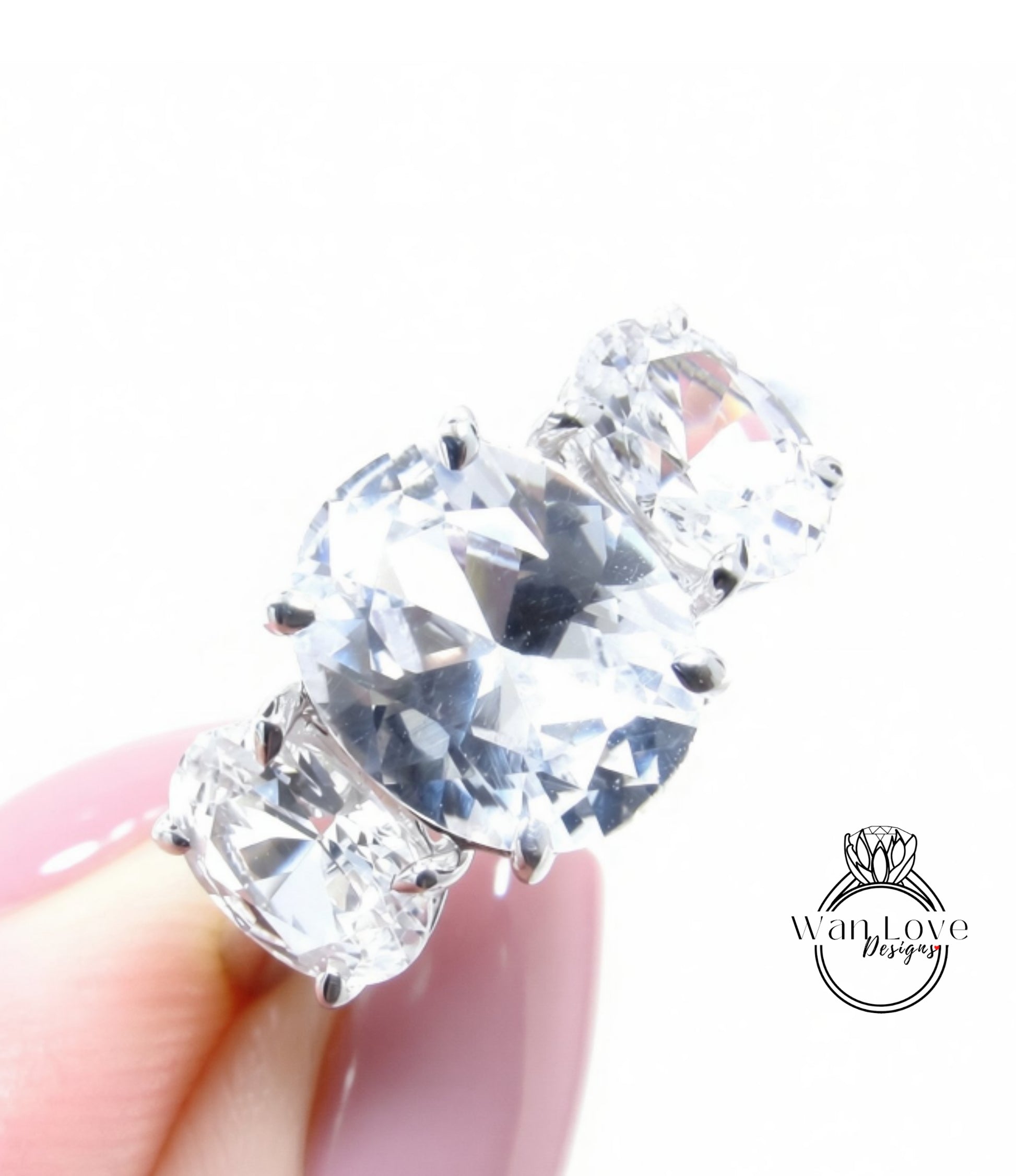 A close-up of a person's hand holding a diamond ring with a large, clear gemstone.