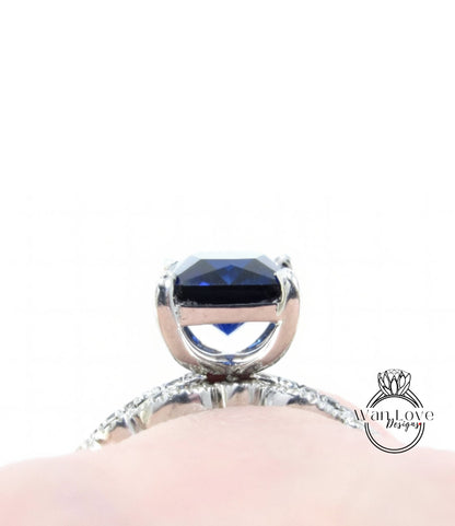A close-up view of a diamond engagement ring with a large blue gemstone set in a silver band.