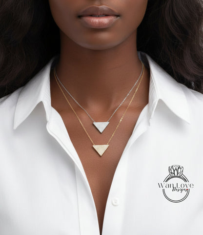 A close-up of a woman wearing a white collared shirt with two diamond-encrusted necklaces.