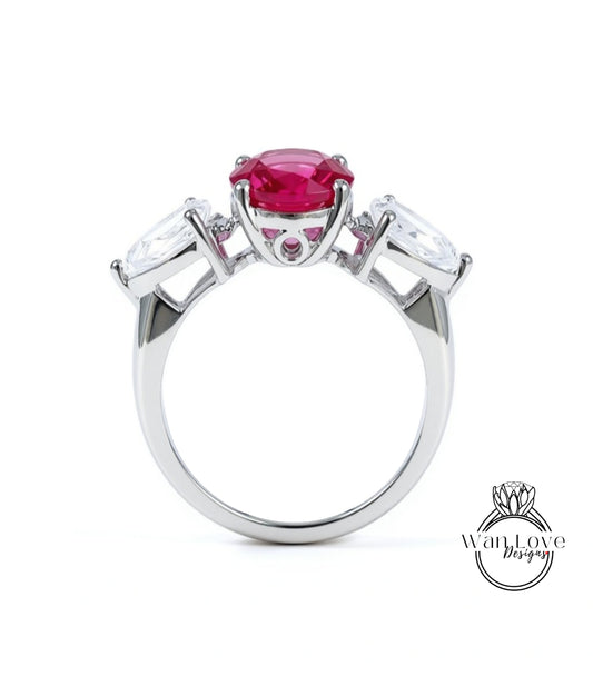 A silver ring with a large pink gemstone in the center, surrounded by smaller white gemstones.