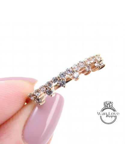 A close-up image of a person's hand holding a gold ring with a row of small diamonds on it.