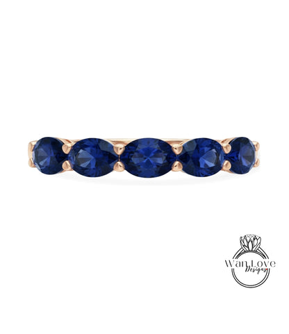 A gold ring with a row of blue sapphire gemstones.