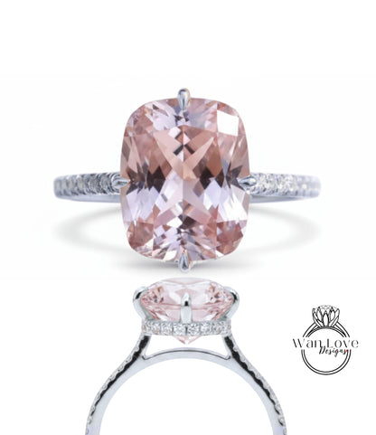 A stunning pink gemstone engagement ring with a large central gemstone surrounded by smaller stones. The ring is set in a silver band with a diamond accent.