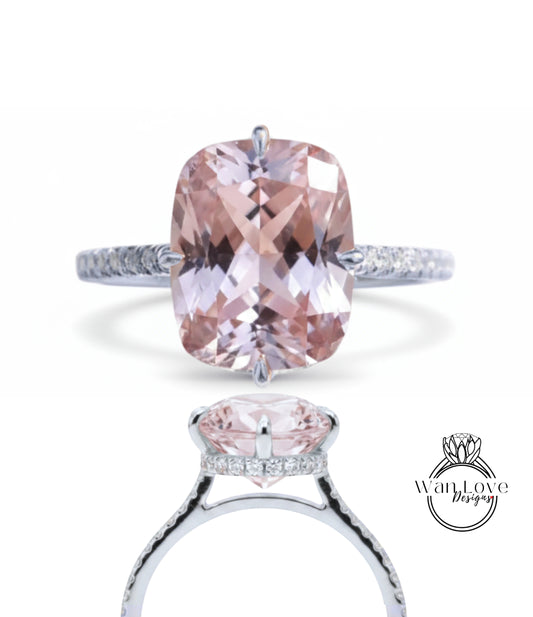 A stunning pink gemstone engagement ring with a large central gemstone surrounded by smaller stones. The ring is set in a silver band with a diamond accent.