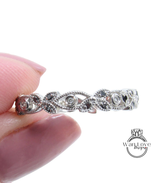 A close-up image of a person's hand holding a silver ring with a decorative design featuring small diamonds.
