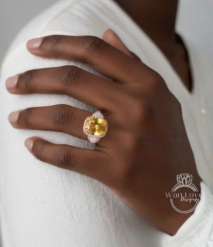 A close-up of a person's hand wearing a large, yellow gemstone ring on the ring finger.