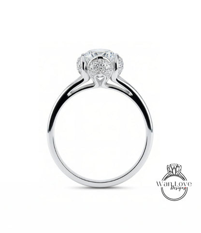 A silver engagement ring with a large central diamond surrounded by smaller diamonds.