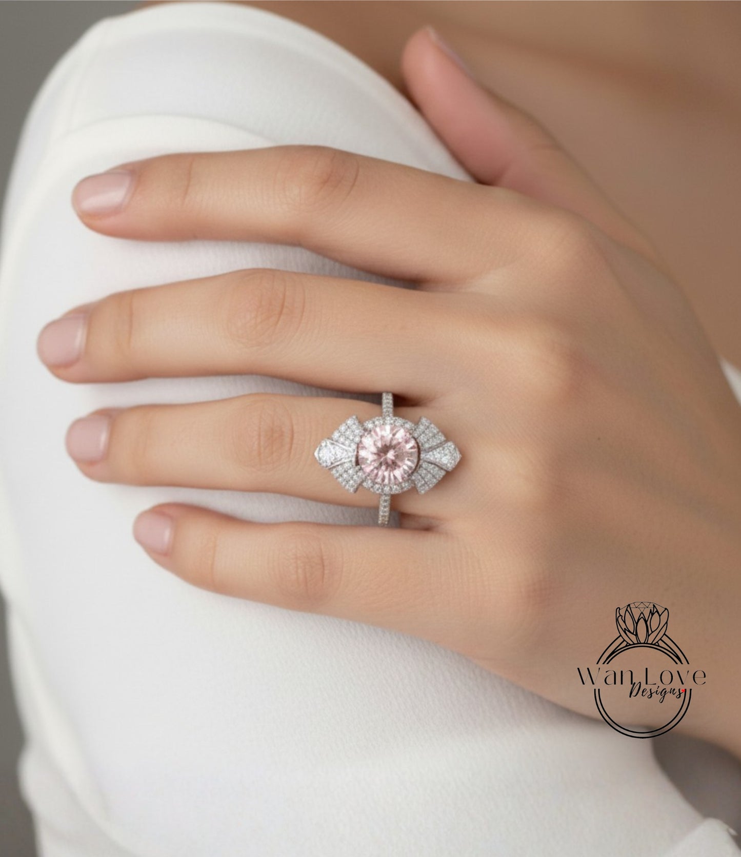 A close-up of a person's hand wearing a large, ornate ring with a pink gemstone.