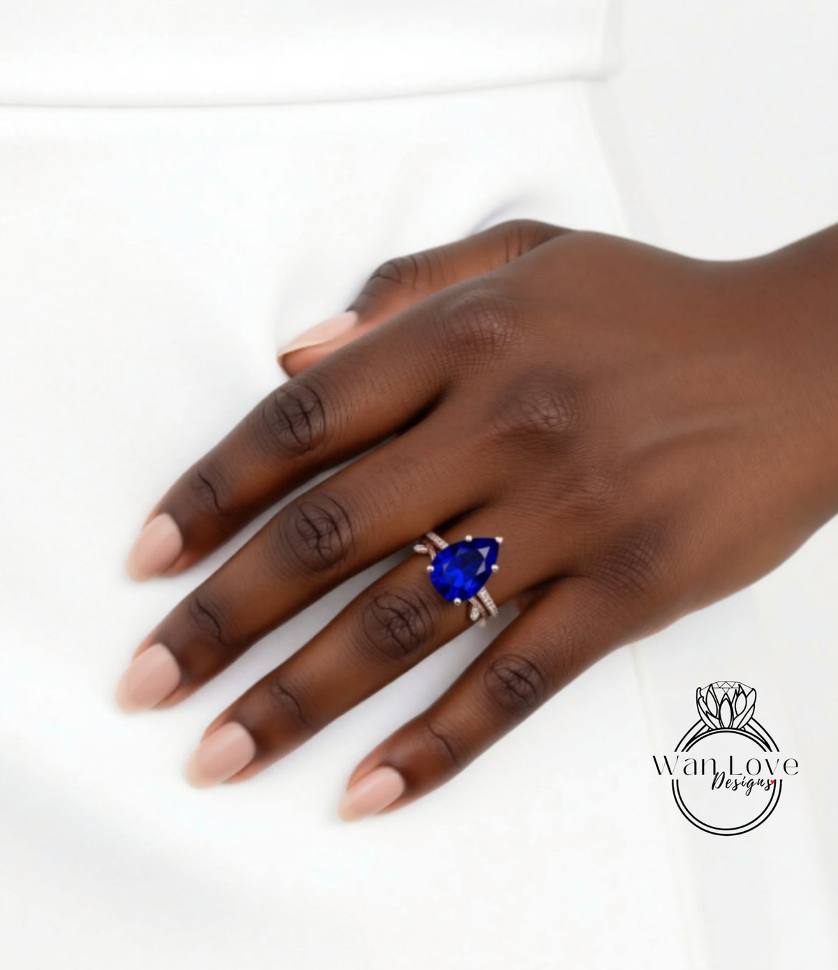 A close-up of a hand wearing a ring with a large blue gemstone.