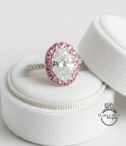 A large oval-shaped diamond ring with a halo of smaller diamonds around the center, placed on a white cloth inside a white box.