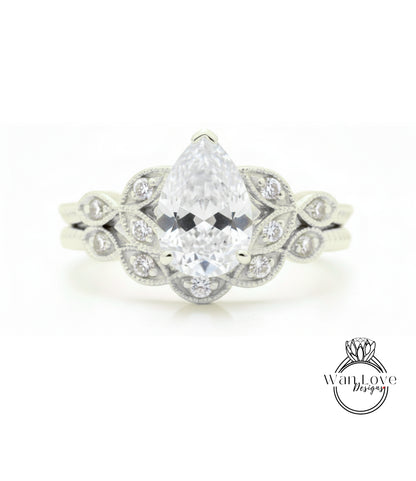 A close-up of a diamond engagement ring with a large pear-shaped diamond at the center, surrounded by smaller diamonds.