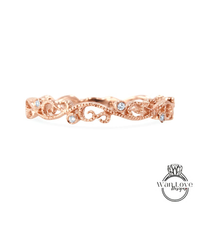 A rose gold ring with a delicate floral design and small diamonds set in the center.