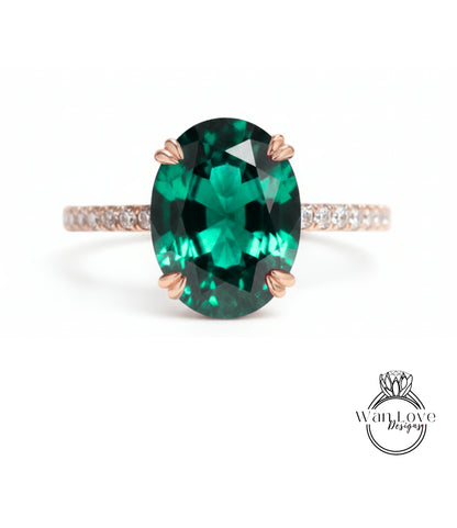 A large oval-shaped green gemstone, possibly a sapphire or emerald, set in a rose gold ring with a thin gold band.