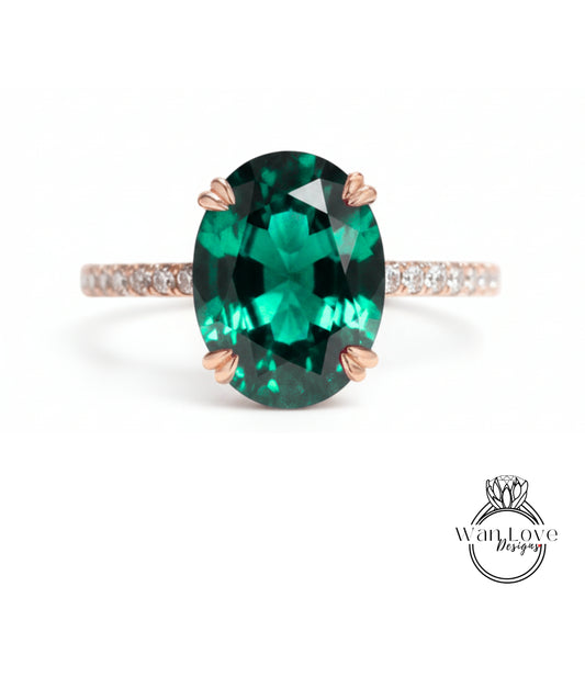 A large oval-shaped green gemstone, possibly a sapphire or emerald, set in a rose gold ring with a thin gold band.