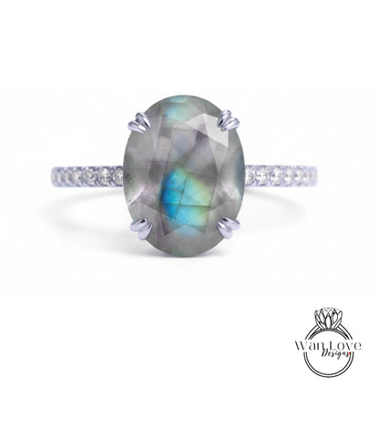 A ring with a large oval-shaped gemstone, possibly a diamond, set in a silver band.