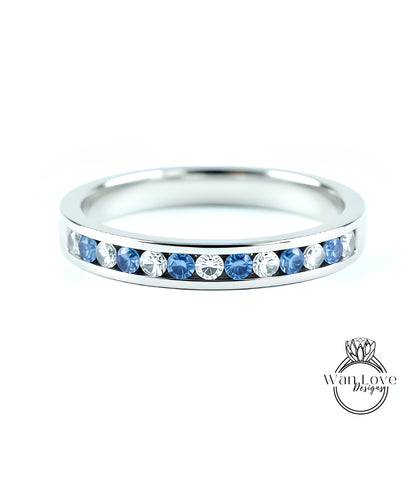 A silver band ring with a row of blue sapphires set in the center.