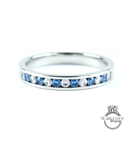 A silver band ring with a row of blue sapphires set in the center.