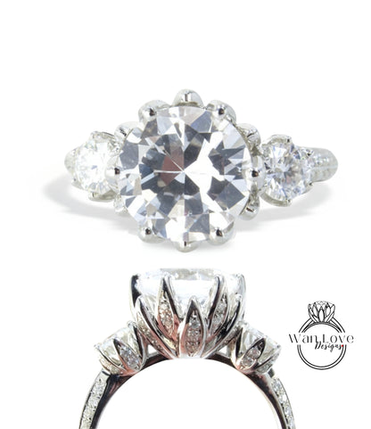a stunning diamond engagement ring with a large central diamond surrounded by smaller diamonds on either side. The ring is set in a silver band, showcasing the intricate design and craftsmanship.