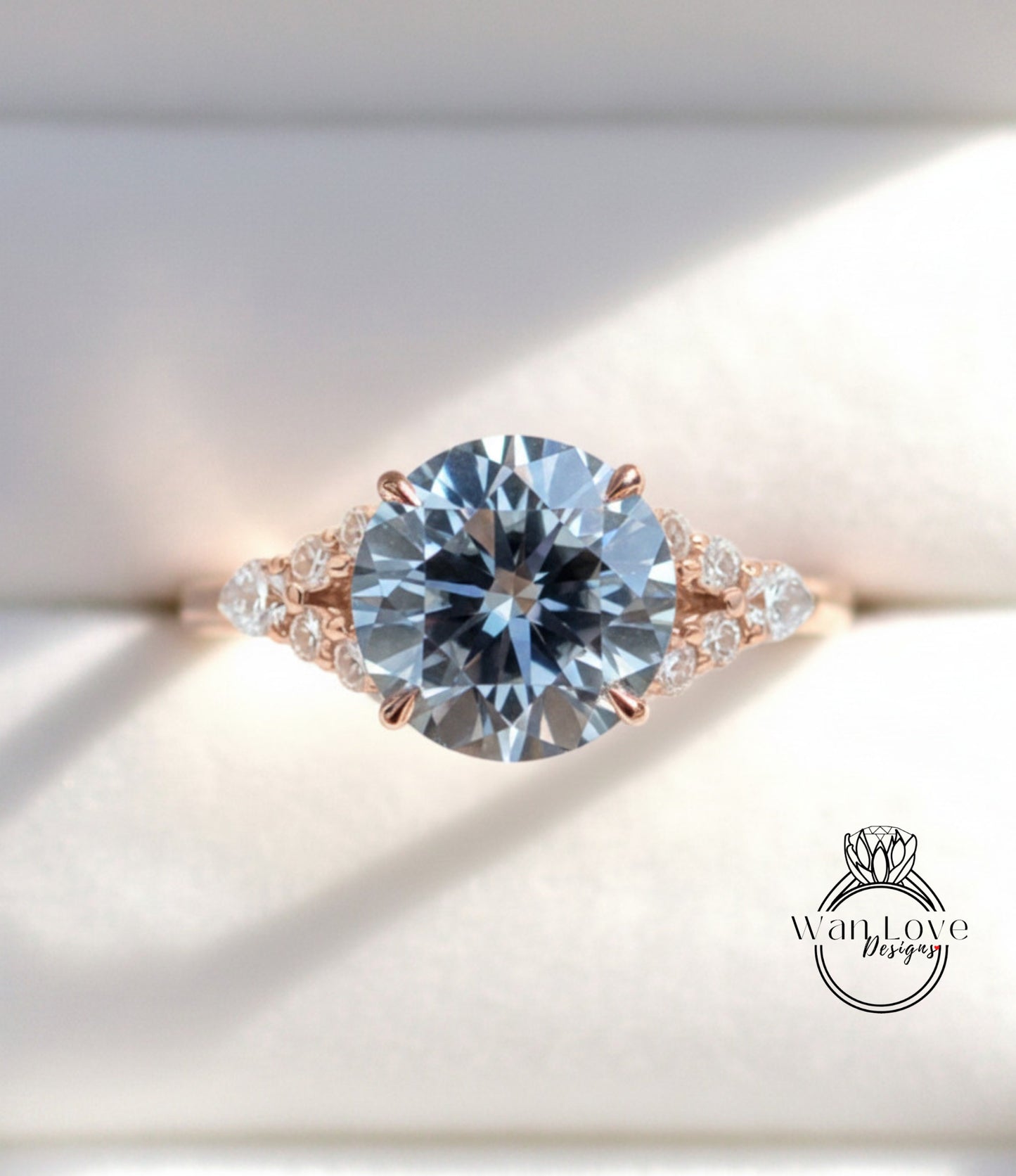 A close-up view of a beautiful engagement ring with a large, round blue diamond set in a rose gold band adorned with smaller diamonds.