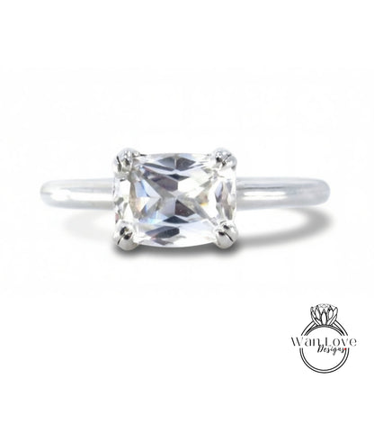 A close-up view of a diamond engagement ring with a large, clear gemstone set in a silver band.