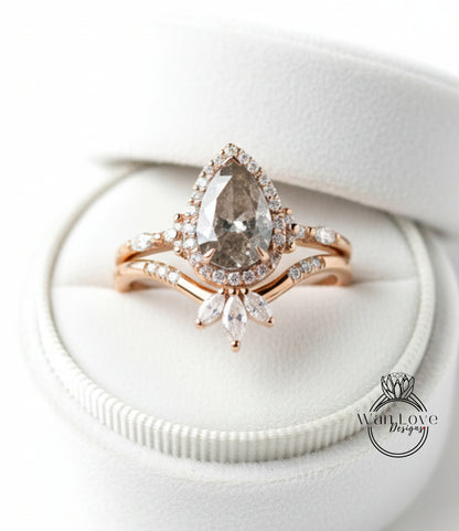 A close-up image of a gold ring with a large diamond set in the center, surrounded by smaller diamonds and a halo of smaller diamonds. The ring is placed in a white jewelry box.