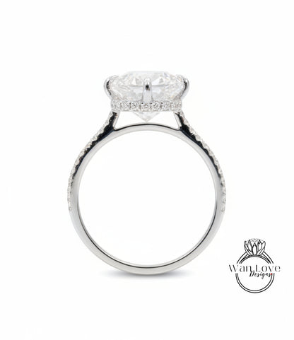 A silver engagement ring with a large, round diamond set in the center, surrounded by smaller diamonds along the band.