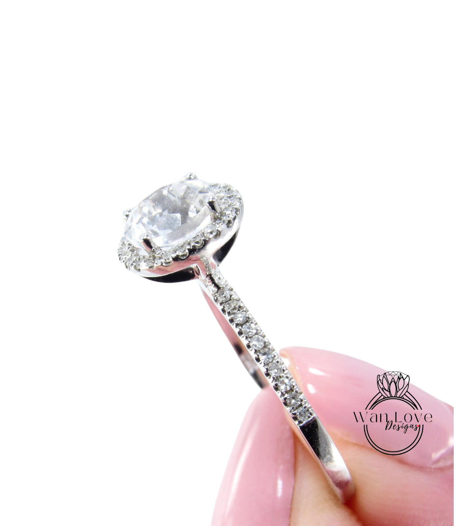A close-up image of a person's hand holding a diamond engagement ring with a large central diamond surrounded by smaller diamonds on the band.