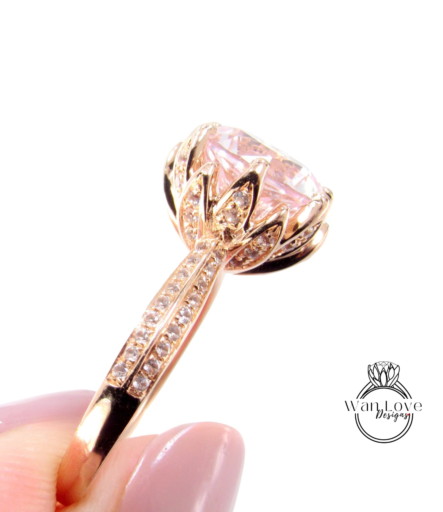 A close-up image of a gold ring with a large, pink gemstone, possibly a diamond, set in a decorative design.