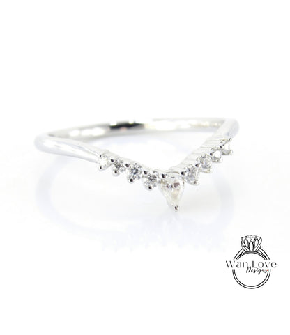 A silver ring with a diamond-encrusted band featuring a v-shaped design with a central pendant.