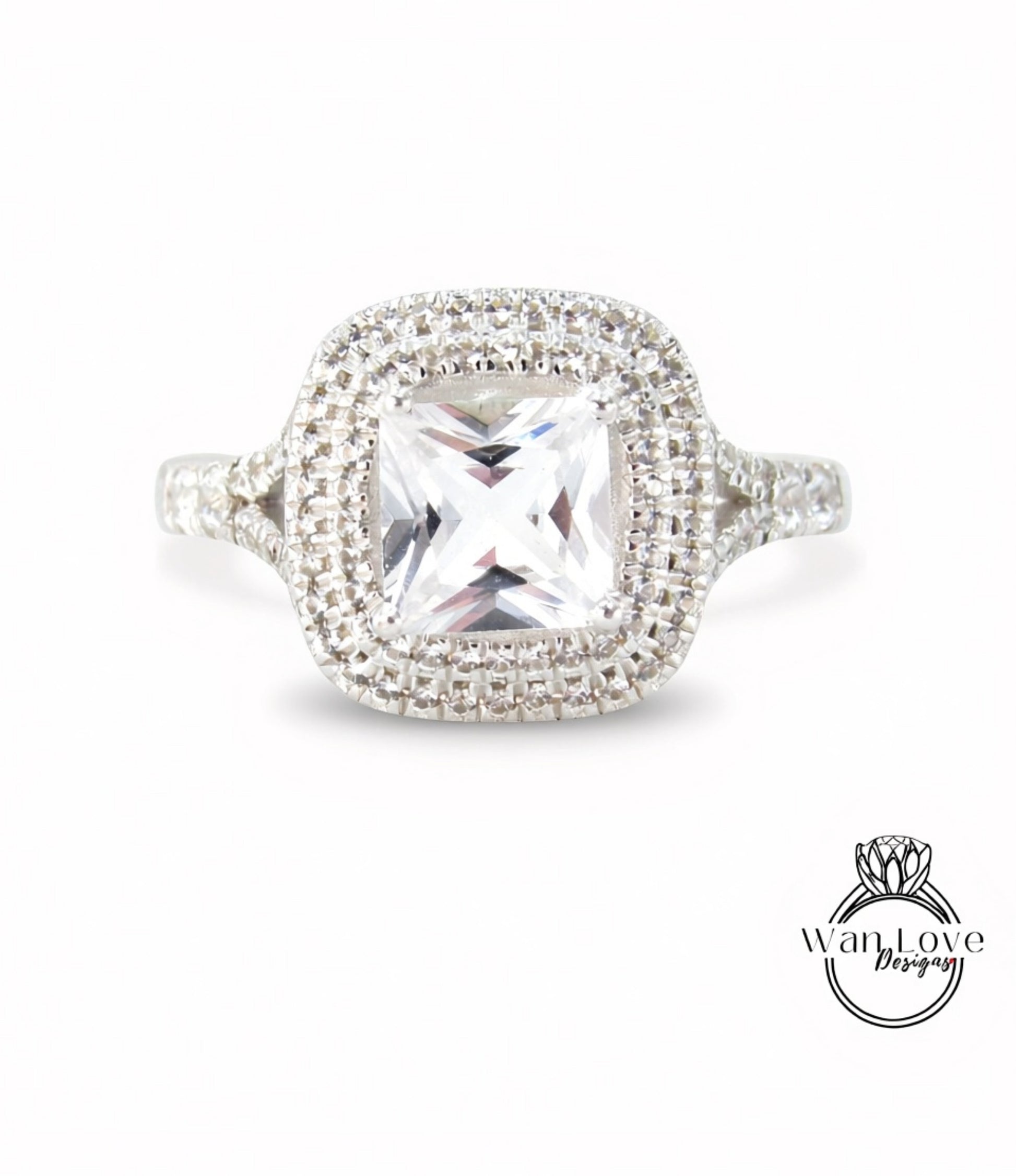 A diamond ring with a large central gemstone surrounded by a halo of smaller diamonds set in a silver band.