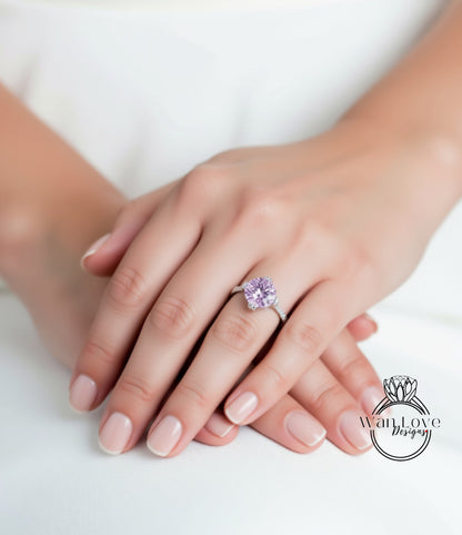 A close-up of a person's hands wearing a ring with a large, purple gemstone.