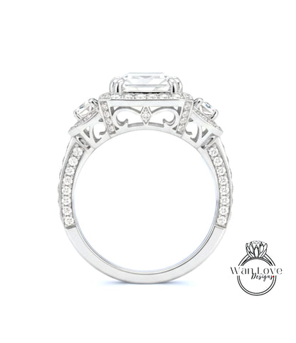 A close-up view of a diamond engagement ring with a large central diamond surrounded by smaller diamonds on either side.