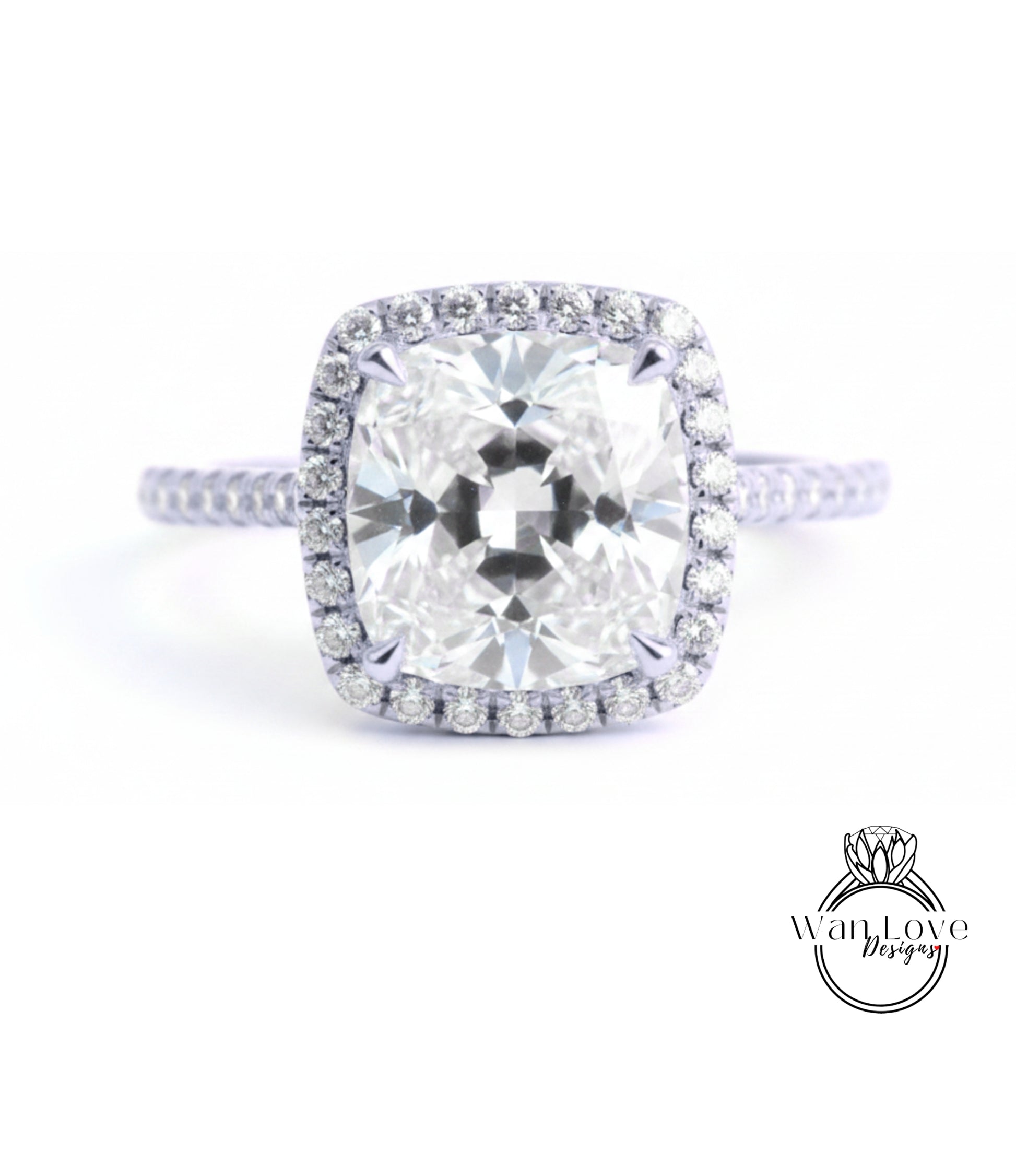 A stunning diamond engagement ring with a large, brilliant-cut diamond set in a halo of smaller diamonds, surrounded by a delicate band of diamonds.